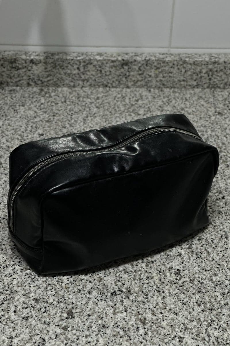 Phone photo: a black wash bag on a granite kitchen counter
