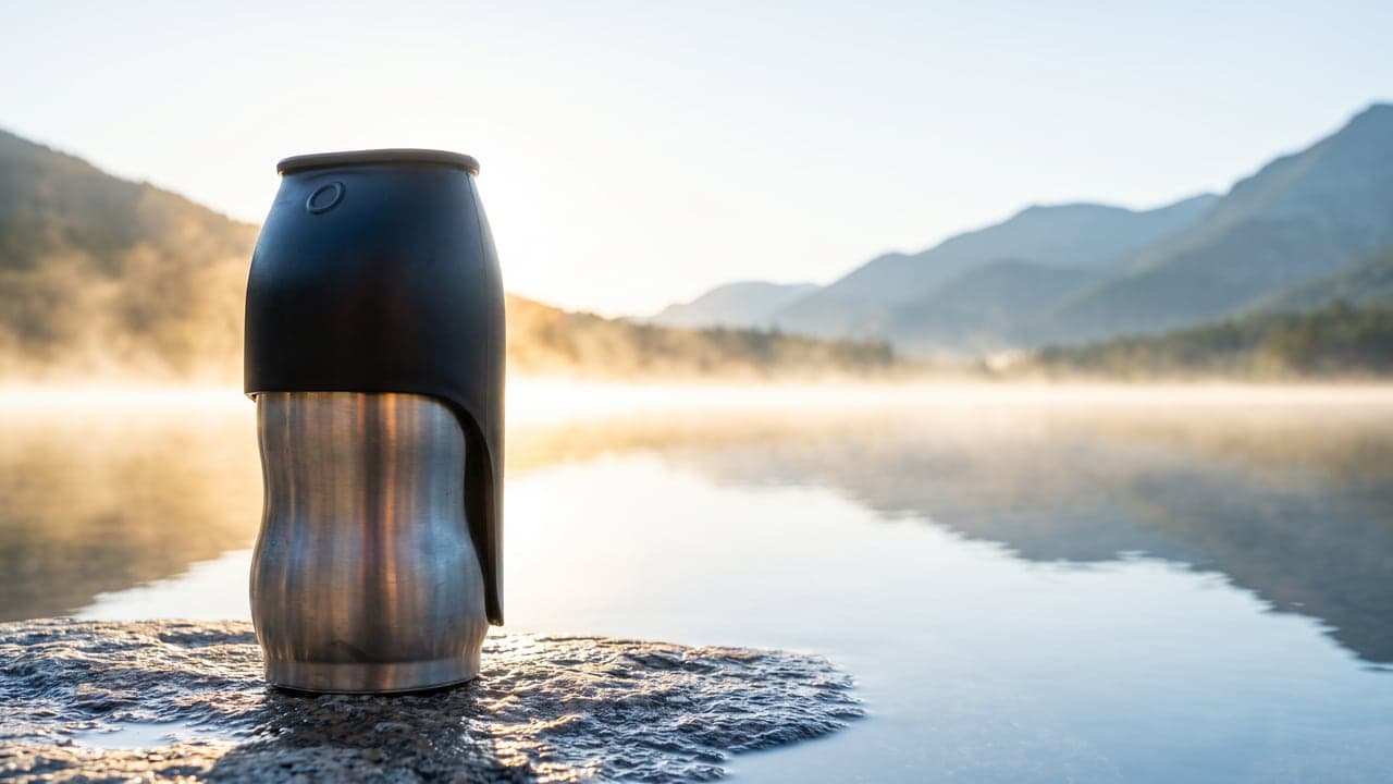 Banner: the flask at the left, the misty lake and the peaks opening out to the right. AI-generated · Nano Banana Pro