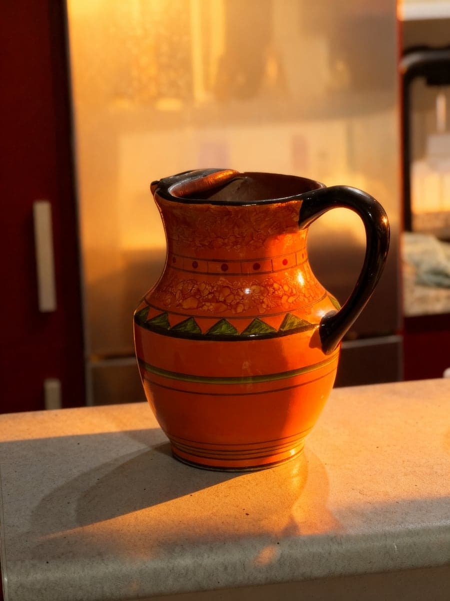 The same jug in warm golden light with a long shadow. AI-generated · Relight