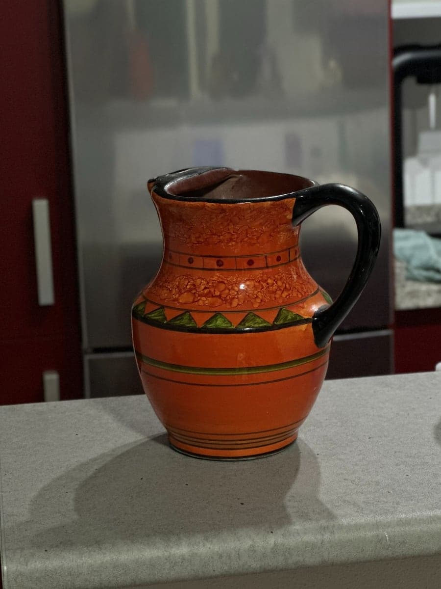 Phone photo: a painted ceramic jug on a kitchen counter